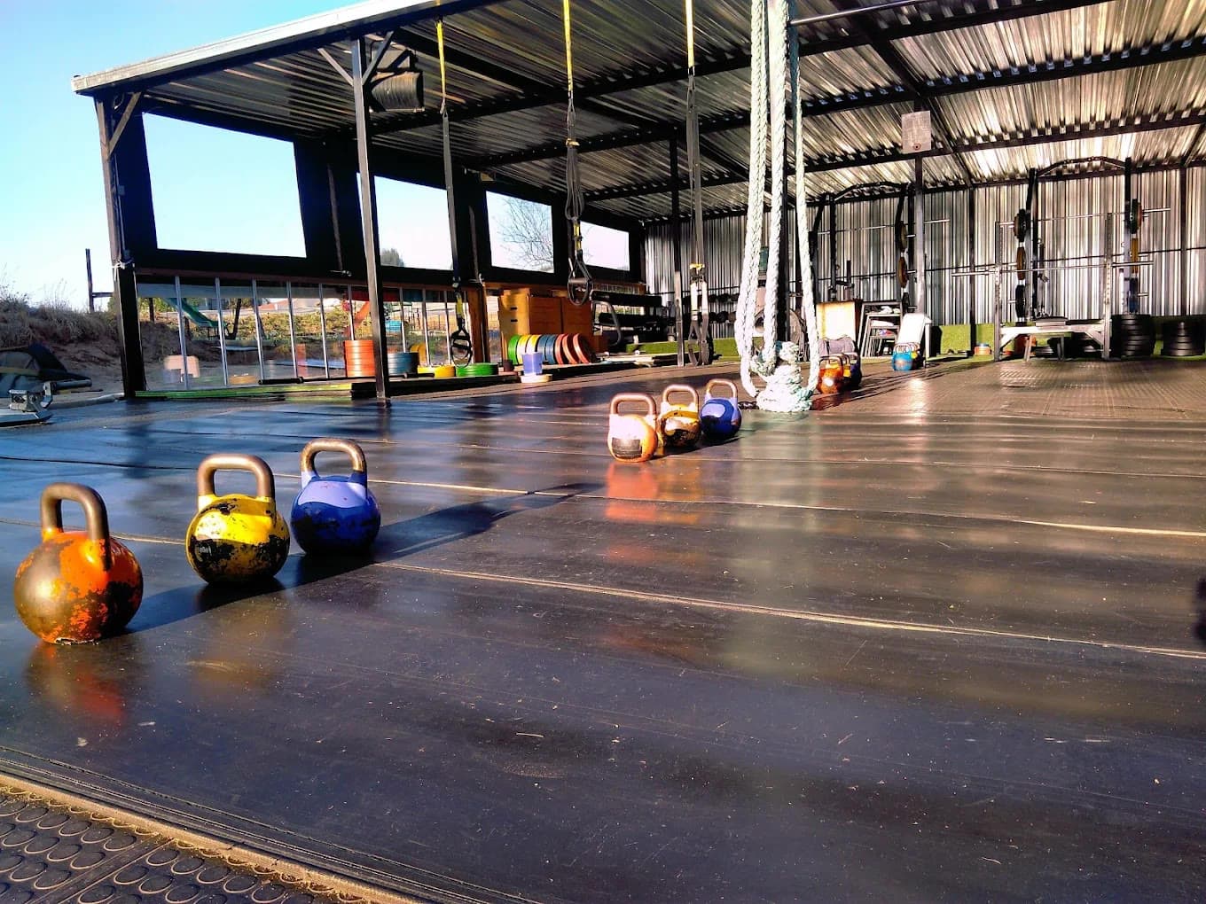 Kettlebells lined up on the FTSA floor before a morning session